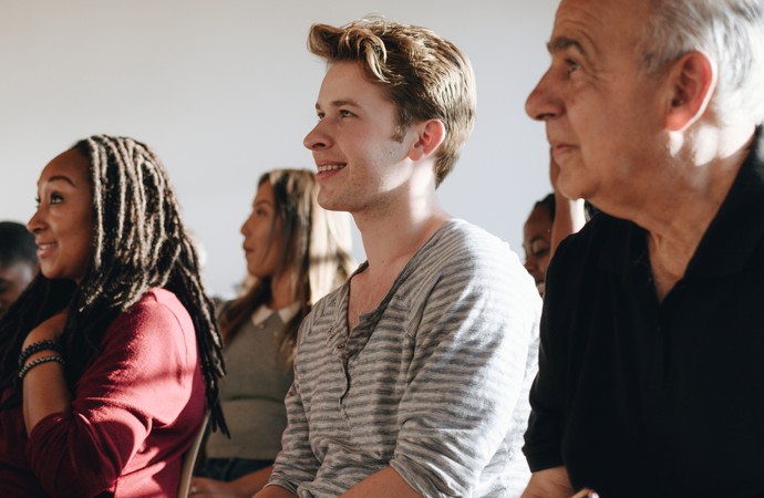 Männer und Frauen verschiedenen Alters besuchen ein Seminar.